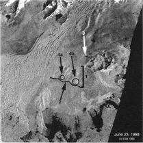 SAR Image of Bering Glacier on June 23, 1993. Surging has become obvious. SAR Image © ESA 1993, James Roush Thesis. 
Bracket 1. A region of bulges is beginning to flow downstream. 
Arrow 2. This line shows the surge front. 
Arrow 3. The dark line above the Grindle Hills may be a melt water pond on the surface in a dip formed by the surge. 
Circles 4a & 4b. Surface bulges.